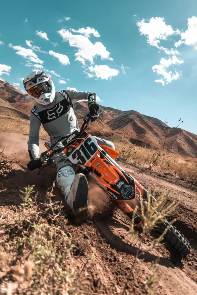 A motocross rider leaning hard into a dirt berm